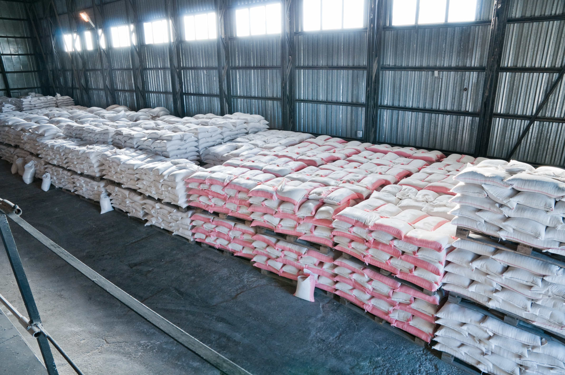Illustrative image: bagged bulk commodities stacked on pallets in a warehouse