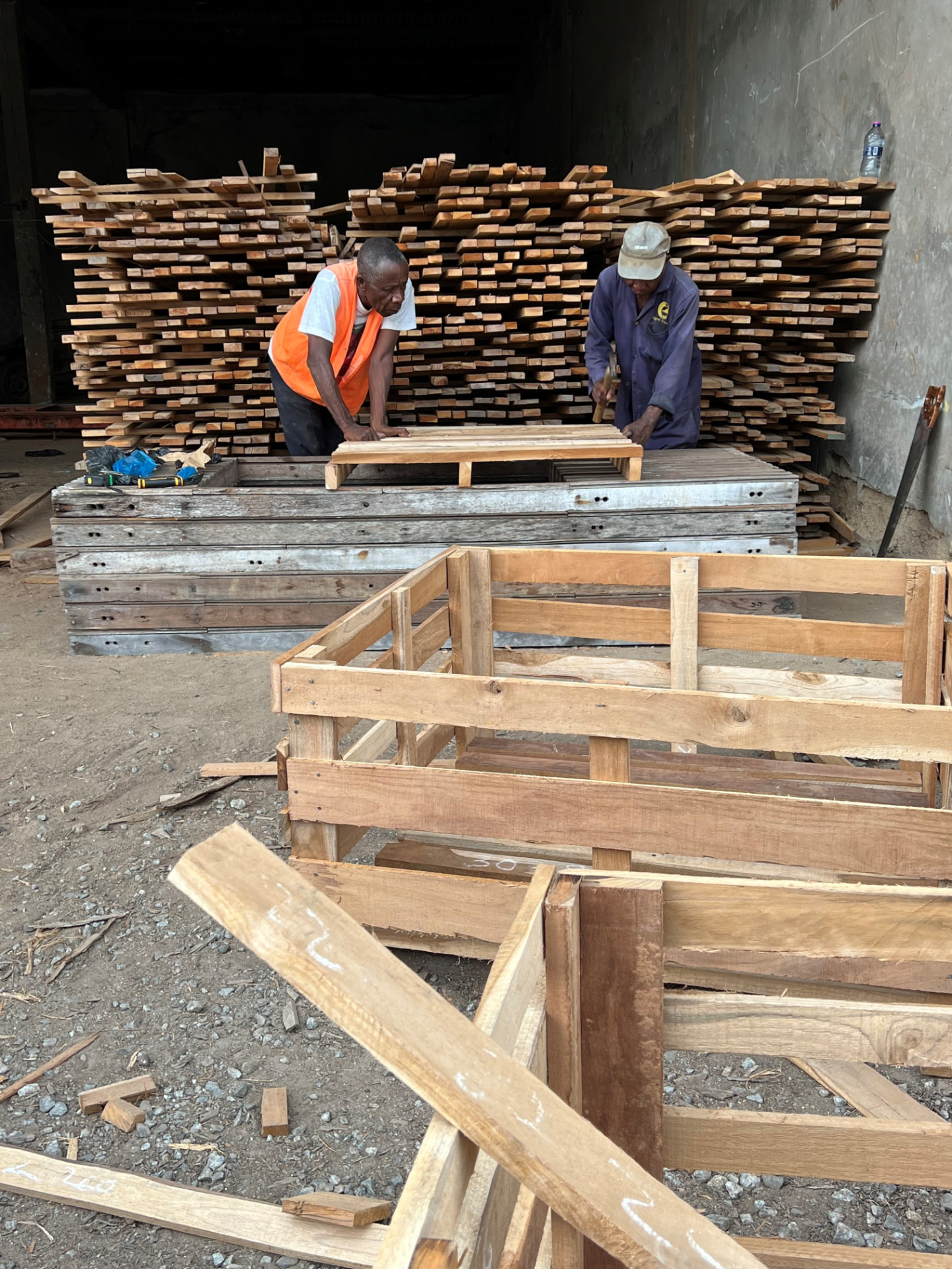 Two workers assembling timber crates in a local workshop